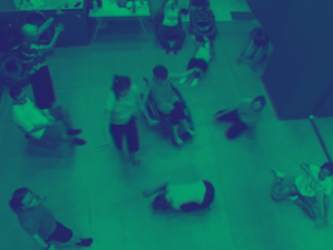 Πανοραμική φωτογραφία του Χώρου με πράσινο φίλτρο. Γύρω στα 10 άτομα είναι απλωμένα στον Χώρο, άλλα καθιστά, άλλα σε κίνηση και μοιάζουν να χορεύουν ελεύθερα.