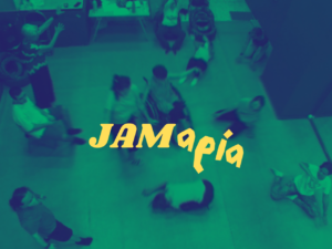 Πανοραμική φωτογραφία του Χώρου με πράσινο φίλτρο. Γύρω στα 10 άτομα είναι απλωμένα στον Χώρο, άλλα καθιστά, άλλα σε κίνηση και μοιάζουν να χορεύουν ελεύθερα. Στο κέντρο της εικόνας με κίτρινους χαρακτήρες που μοιάζουν χειρόγραφοι είναι γραμμένο JAMαρία (τζαμαρία).