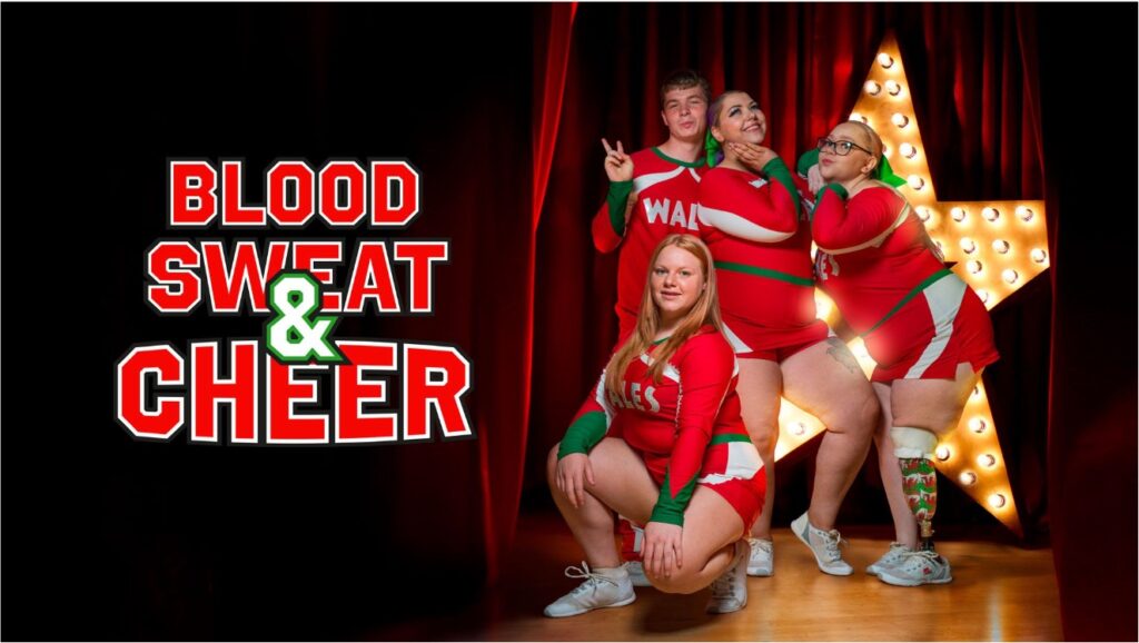 Αφίσα της ταινίας ντοκιμαντέρ Blood Sweat and Cheer. Μία ομάδα cheerleaders αποτελούμενη από ένα νεαρό αγόρι και τρεις κοπέλες ποζάρει χαρούμενη ανάμεσα σε κόκκινες βελούδινες κουρτίνες και μπροστά από ένα φωτεινό αστέρι στο φόντο. Μία από τις κοπέλες στηρίζεται σε τεχνητό πόδι, ενώ και τα σώματά των υπολοίπων πλούσια σε καμπύλες διαφέρουν από τον αναμενόμενο σωματότυπο του αθλήματος. Τα νέα παιδιά ποζάρουν εύθυμα και περήφανα με κόκκινα μπλουζάκια που γράφουν WALES και κοντά σορτσάκια.