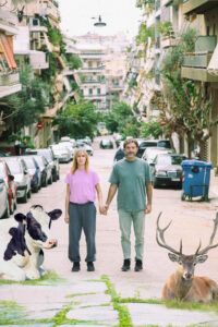 Μία αγελάδα και ένα ελάφι πλαισιώνουν μια γυναίκα κι ένα άνδρα με καθημερινά ρούχα που ποζάρουν χέρι χέρι σε κεντρικό σημείο της πόλης ανάμεσα από πολυκατοικίες. Η παρουσία των ζώων εκεί μες στην απόλυτη ηρεμία τους έχει κάτι το αλλόκοτο και σουρεαλιστικό.